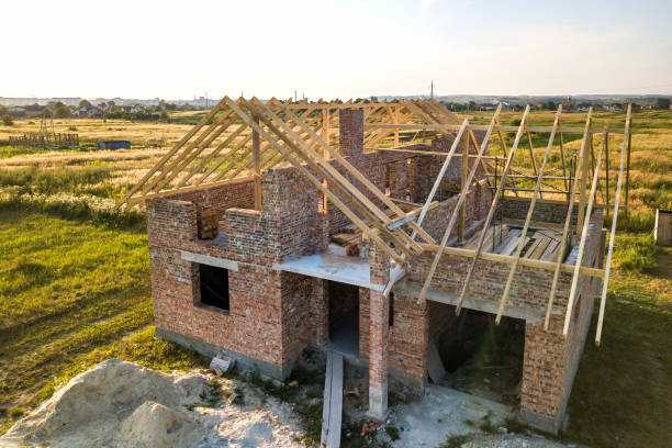 istock Unfinished brick house with wooden roof structure under construction. 1216762145