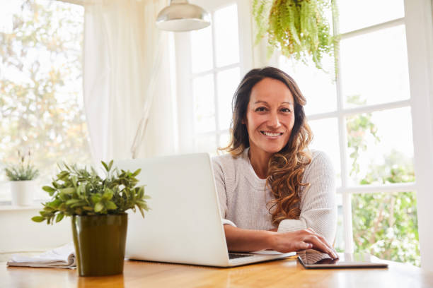 istock Mature woman smiling while working online from home 1216762178