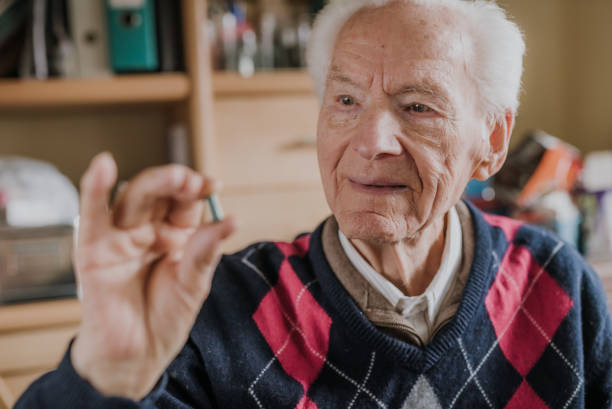 istock Old man holding one green tablet in hand closeup 1216762205