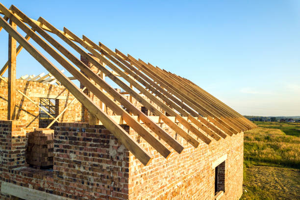 istock Unfinished brick house with wooden roof structure under construction. 1216762457