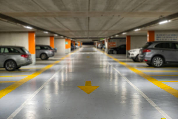 marcas amarelas com carros modernos embaçados estacionados dentro de estacionamento subterrâneo fechado. - building feature parking garage stationary built structure - fotografias e filmes do acervo