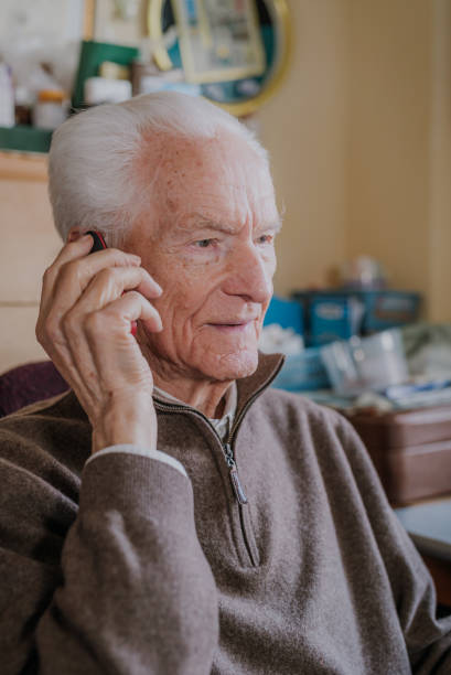 istock Elderly man talking on phone sitting at home 1216762679