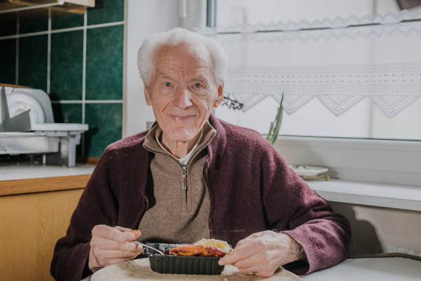 Portrait senior eats dinner at home