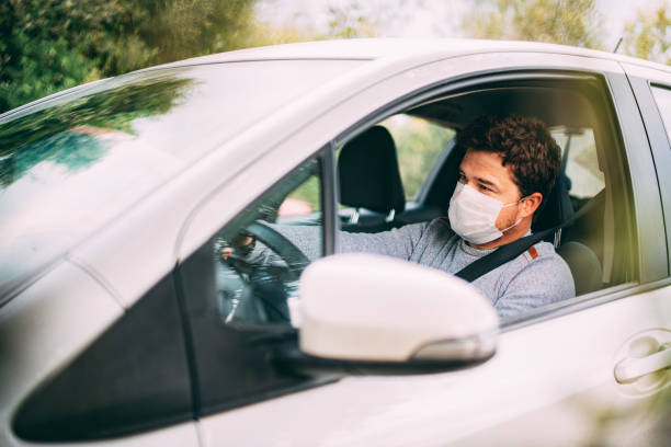 istock Man Wearing a Sterile Mask Driving a Car 1216765418