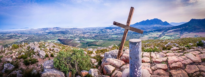 Easter religious background greeting card - Crucifixion and resurrection of Jesus Christ at Golgota (Golgotha), crucifix with jesus christ, blue cloudy sky and bright shining sunshine over cross