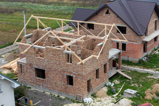 istock Unfinished brick house with wooden roof structure under construction. 1216766393