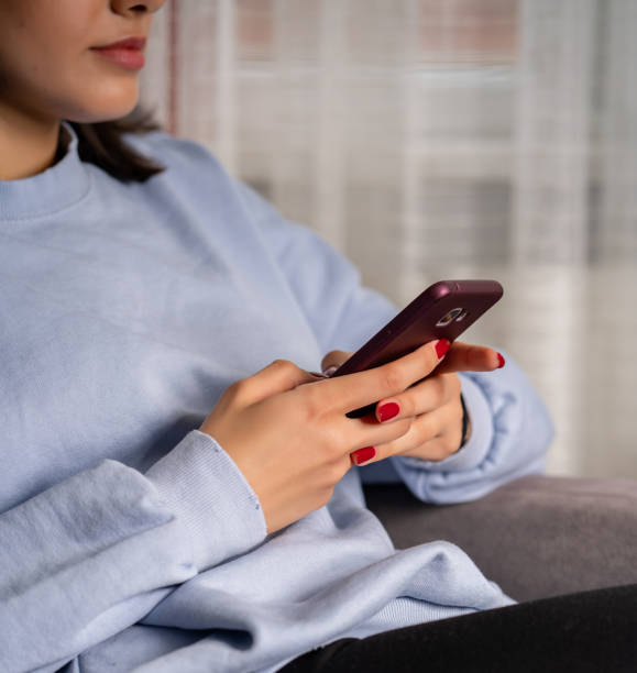 istock Young woman is using phone from home during quarantine time 1216766412