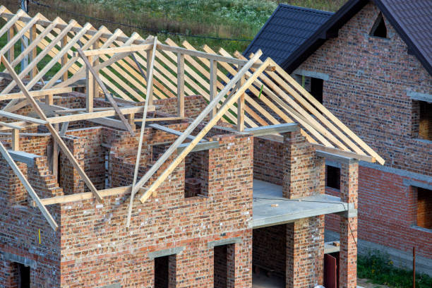 istock Unfinished brick house with wooden roof structure under construction. 1216766604