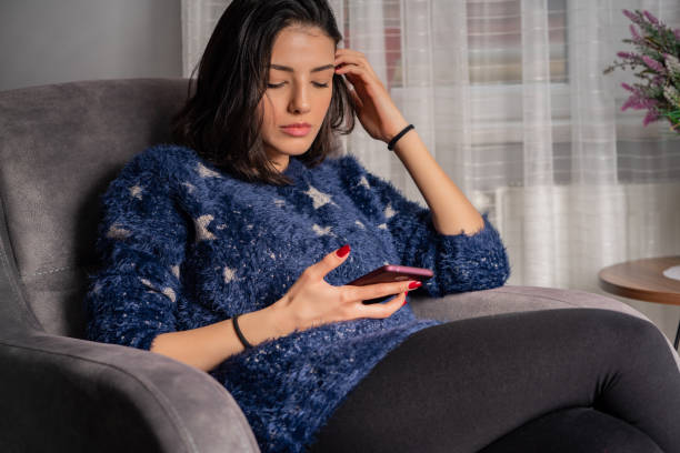 istock Young woman is using phone from home during quarantine time 1216767700