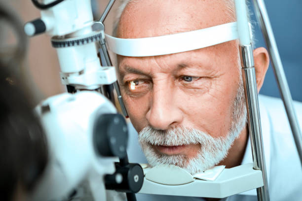 istock Optometrist examining senior mans eyes through slit lamp 1216771812