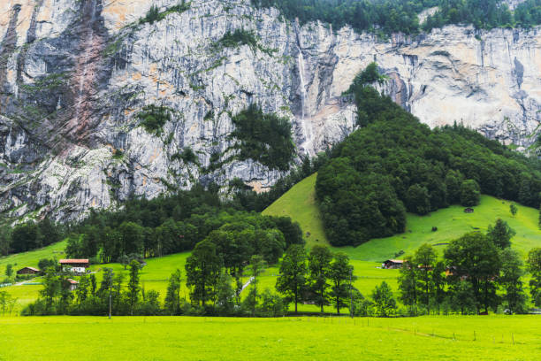 Scenic view of a tiny mountain village in the forest in Switzerland Beautiful village of Lauterbrunnen surrounded by the mountains, pine forest and waterfalls in Swiss Alps during bright sunny summer day jungfrau stock pictures, royalty-free photos & images