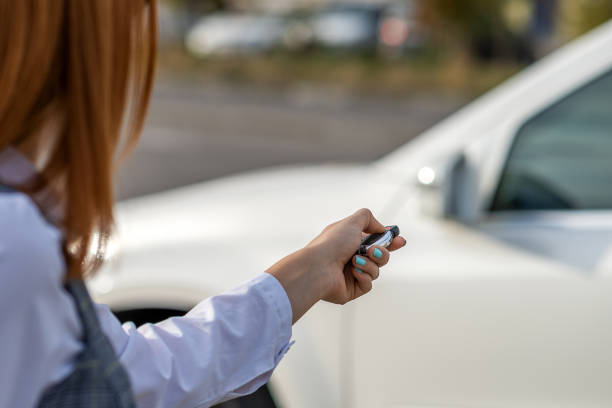 istock Redhead girl unlocking a car with wireless key. 1216777566
