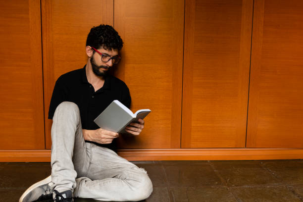 istock Hispanic man looking to distract himself by reading a book during quarantine 1216777876