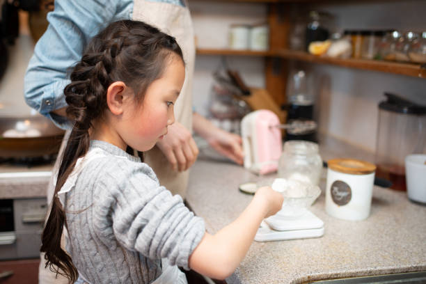 istock Mother and daughter making cake at home 1216777906