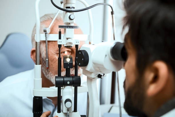 istock Optometrist examining senior mans eyes through slit lamp 1216779951