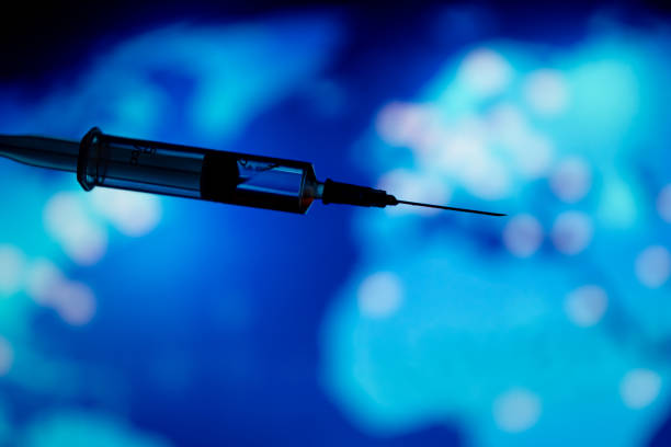 istock Medical syringe for a vaccine. Blue background. 1216781252