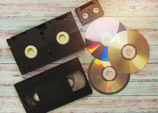 istock Cassettes for a VCR, CD discs on a wooden background. Vintage. Retro 1216781456