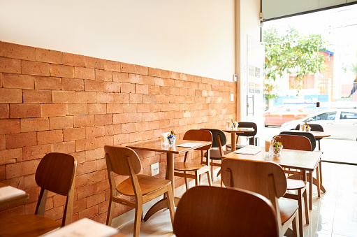 Shot of small coffee shop interior with wooden tables and chairs
