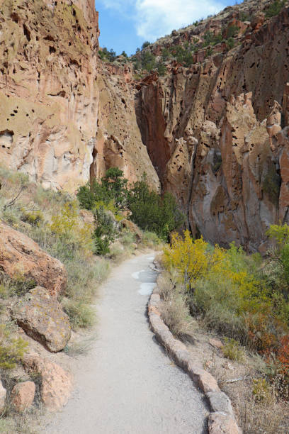 Pathway along the main loop trail at the base of cliffs in Frijoles Canyon at Bandelier National Monument near Los Alamos, New Mexico in autumn