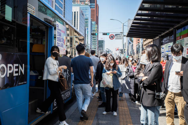 People getting off a bus People wear masks on their faces and get off the bus at the bus stop located in the Gangnam area. This is a scene where many citizens are friendly and supportive of strict social distance and prevention of COVID19 disinfection. seoul province stock pictures, royalty-free photos & images