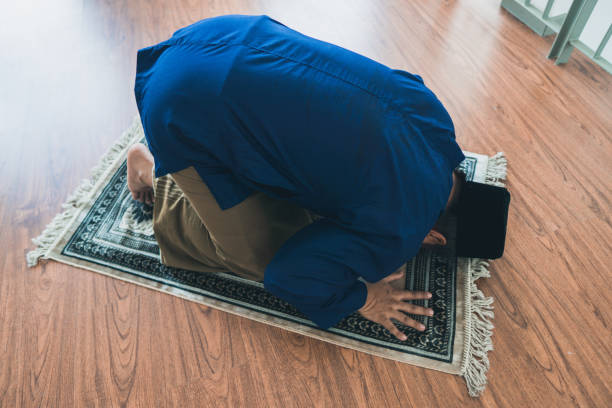 Ramadhan concept stock photo where a muslim man performing solat at his home stock photo