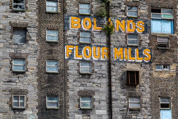 closeup front facade view of the old abandoned in decay factory mill with company name. - dublin ireland brick built structure building exterior imagens e fotografias de stock