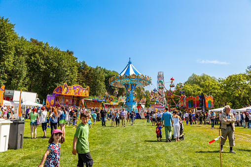 Sundbyberg, Sweden - June 6, 2013: Open summer view of many people at a funfair amusement park on a green lawn at public park in Sundbyberg Sweden June 6, 2013.