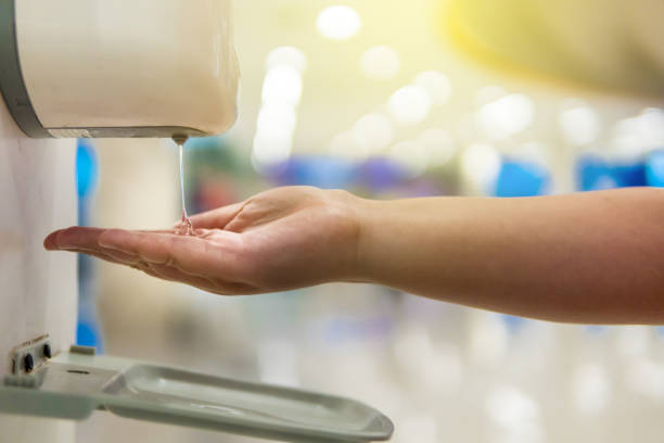 el niño está tomando gel de alcohol de la máquina automática de goteo en el centro comercial. - hand sanitizer liquid soap hygiene healthy lifestyle fotografías e imágenes de stock