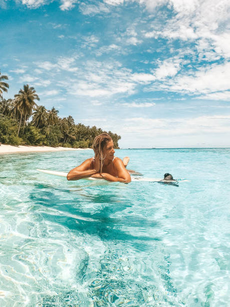istock Girl on her surfboard with tropical background 1216787206