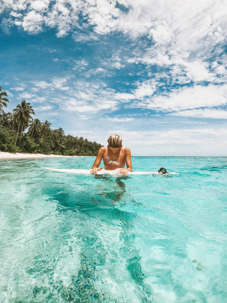 istock Girl on her surfboard with tropical background 1216787829