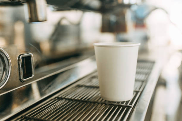 White coffee Cup in the coffee machine. A cardboard Cup for coffee with you.