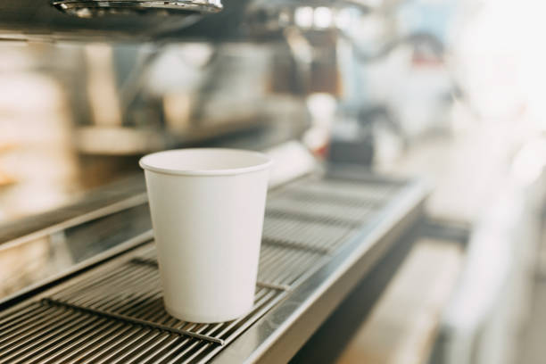 istock White coffee Cup in the coffee machine. A cardboard Cup for coffee with you. 1216787976