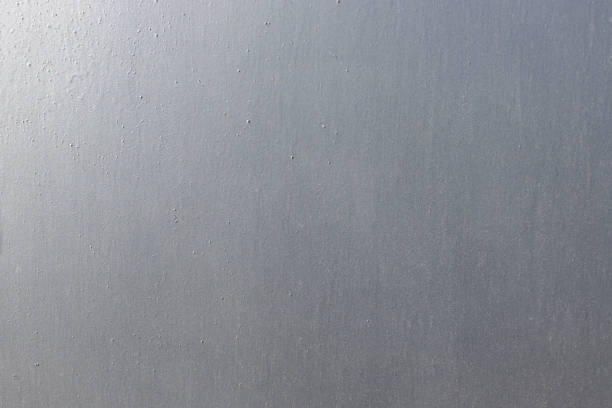 surface of a metal sheet painted in gray paint. silver background, abstract metal texture.
