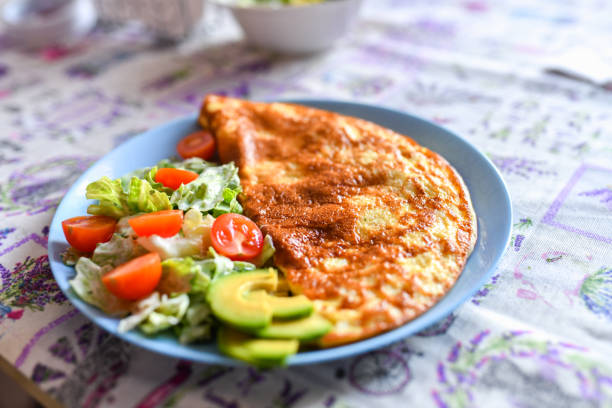 fried eggs with vegetables. On a light background. breakfast for one.