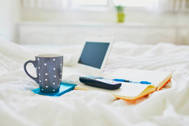 istock Laptop, cup of coffee, notebook and phone in bed 1216789373