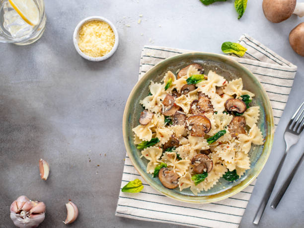 istock farfalle pasta with mushrooms and spinach, served in a ceramic plate. 1216789680