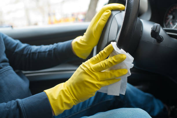 istock Man's hands wearing rubber gloves disinfecting and cleaning car interior 1216791017