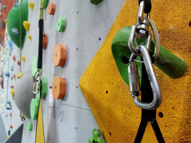 istock climbing on artificial wall indoors. Climbing equipment ,gym rope and Rock Lock Screwgate Carabiner for moving up on steep rock, Extreme sports and bouldering concept. 1216791107