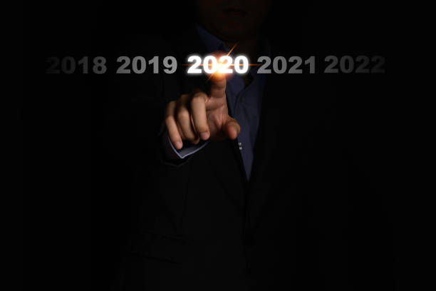 main d’homme d’affaires touchant 2020 année sur le fond noir. c’est le symbole du changement de l’exercice et de l’exercice. - eyesight concepts ideas human hand photos et images de collection