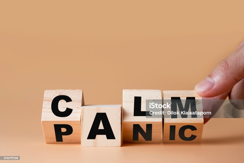 Hand flipping wooden cubes for change wording" Panic "  to " Calm".  Mindset is important for human development. Anxiety Stock Photo