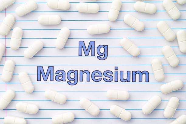 The word magnesium and magnesium tablets around it The word magnesium and magnesium tablets around it. Close up. magnesium deficiency stock pictures, royalty-free photos & images