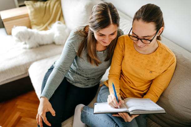 istock Mother helping daughter with homework 1216794073