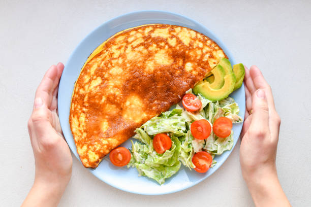 istock omelet with vegetables on a plate. blue plate. view from above. Omelet with vegetables on a plate served for breakfast. View from above 1216794996