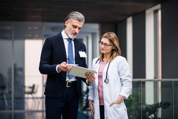 istock Pharmaceutical sales representative with tablet talking to doctor. 1216795228