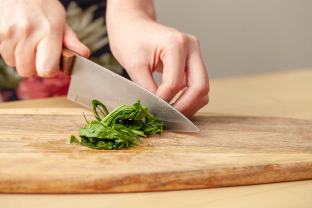 istock Cooking spinach leaves on a cutting Board in the kitchen. 1216796292