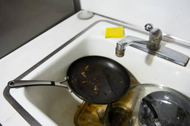 This is a candid photograph of dirty dishes in the kitchen sink at home.