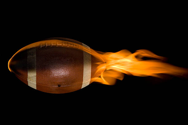 football with dramatic lighting and shadows isolated on black background