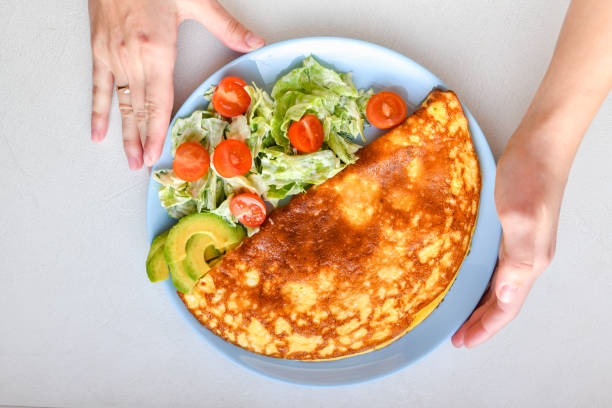 istock omelet with vegetables on a plate. blue plate. view from above. Omelet with vegetables on a plate served for breakfast. View from above 1216800244