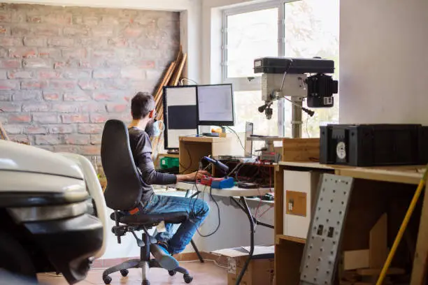 Photo of Man working at his temporary home office in his garage