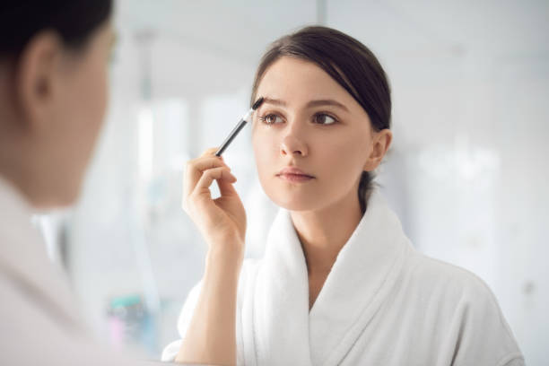 istock A young woman brushing the eyebrows 1216801502